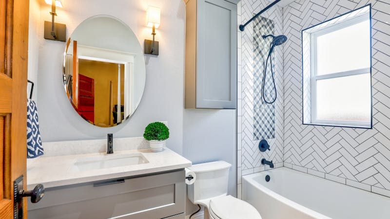 Baie modernă cu gresie decorativă tip herringbone — ghid alegere gresie pentru baie