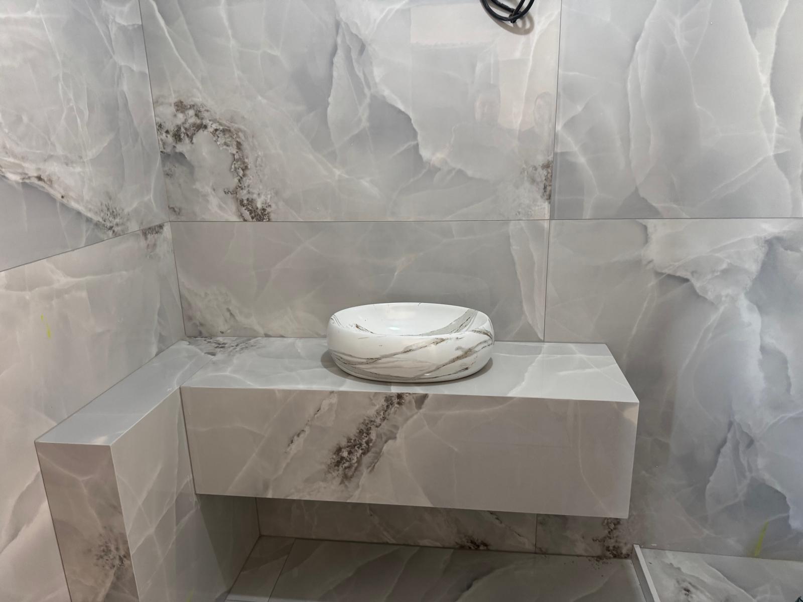 Placare baie cu faianță efect onyx, blat și chiuvetă din ceramică, lucrare realizată de Eugen Arginta