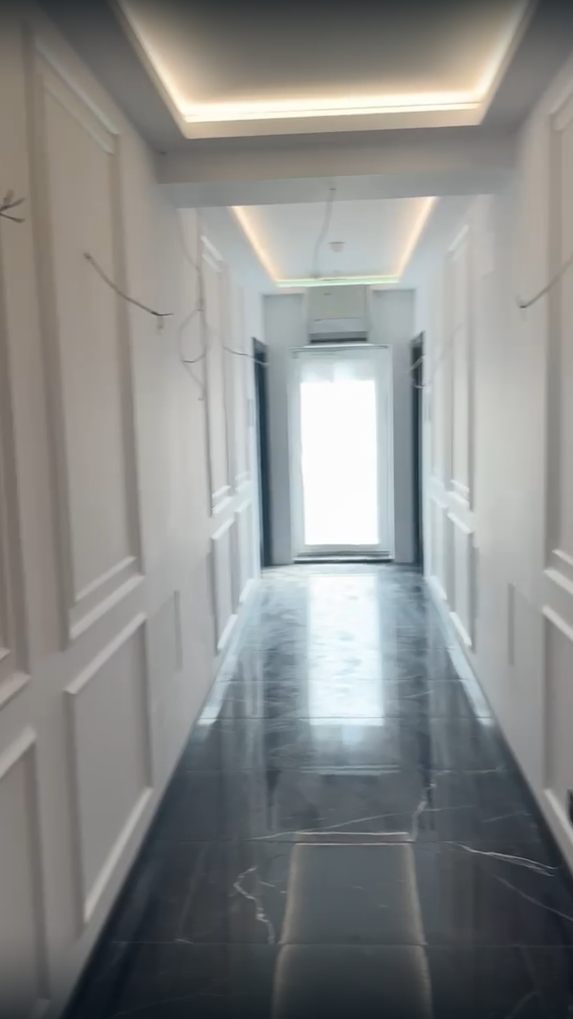Hol cu lambriu decorativ alb, lumină ascunsă LED și pardoseală din marmură neagră – lucrare realizată de Eugen Arginta